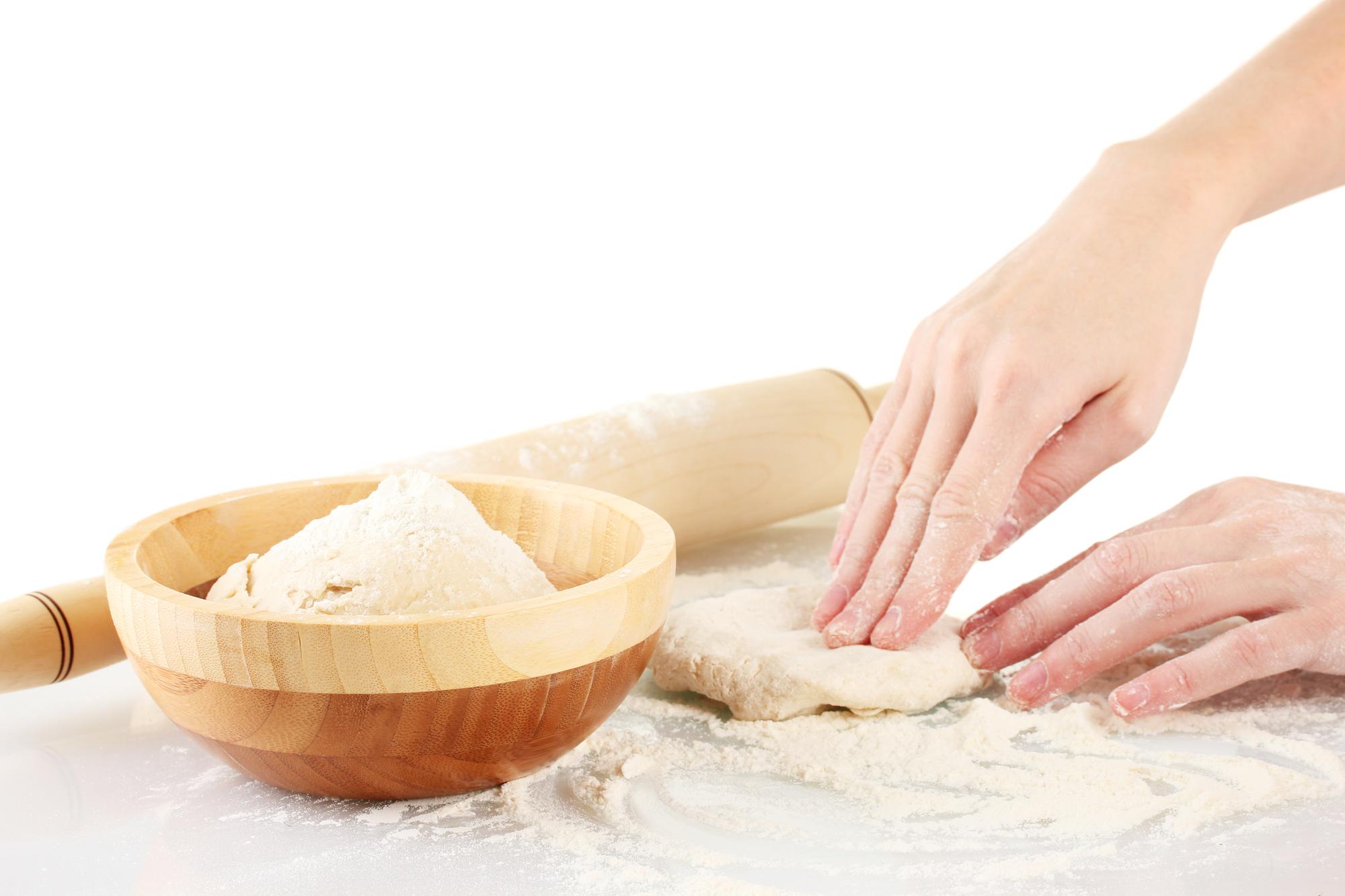 hands kneading dough in warm light